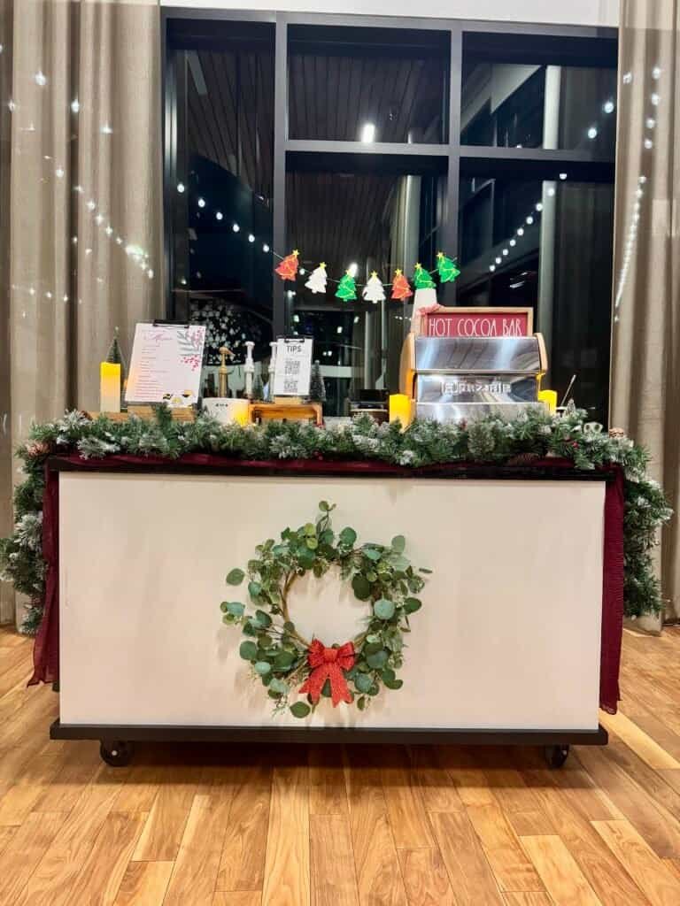 Festive coffee stand decorated with Christmas wreath and holiday lights at Sunny Cups Coffee.