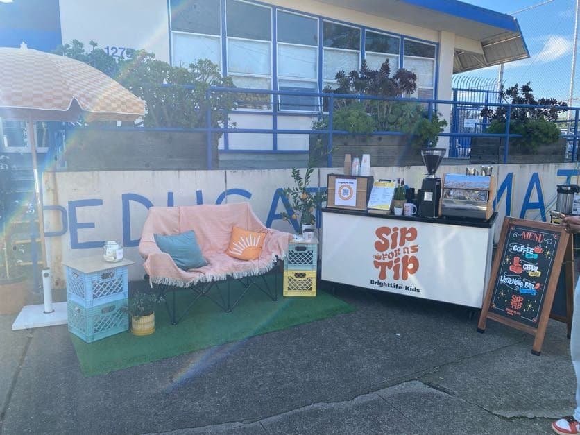 Outdoor coffee stand with seating area and menu board at Sunny Cups Coffee.