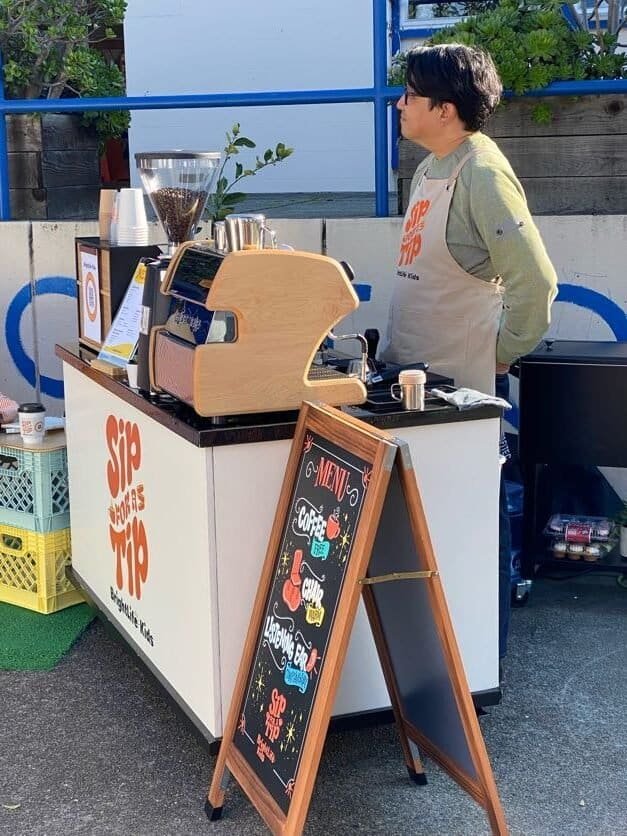Sunny Cups Coffee outdoor coffee stand with barista preparing drinks.