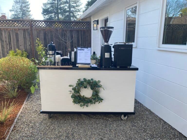 Outdoor coffee cart with coffee grinder and menu board.