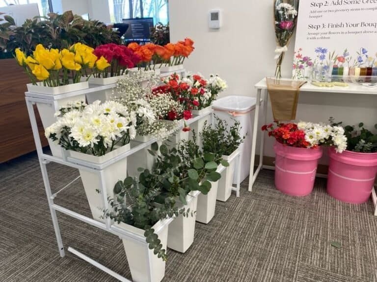 A vibrant arrangement of colorful flowers including yellow, red, white, and pink blooms on a white s.