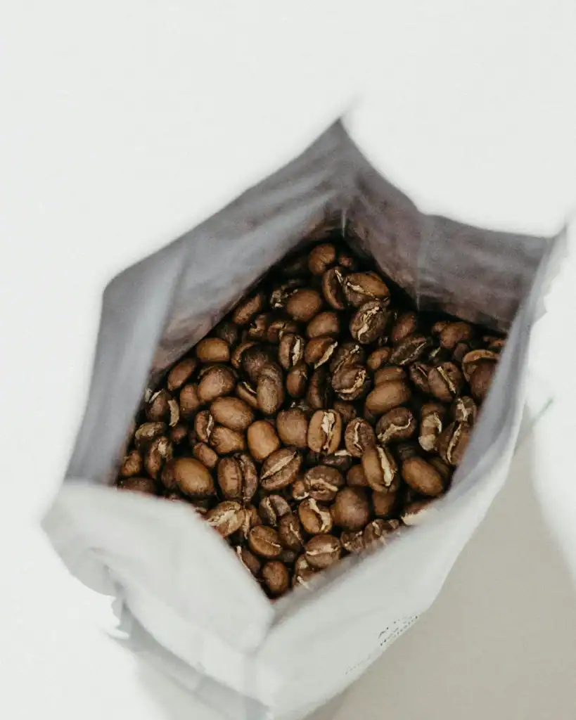 Fresh roasted coffee beans in an open bag.