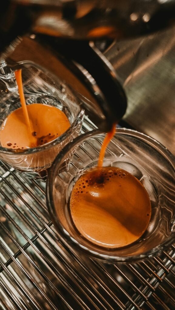 Pouring fresh espresso into glasses at Sunny Cups Coffee.